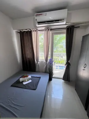 a bedroom with a blue bed and a window at Unistay SHORE Residence amazing pool view in Manila