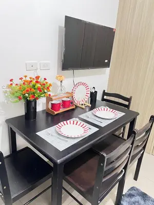 a black table with two plates and flowers on it at Unistay SHORE Residence amazing pool view in Manila
