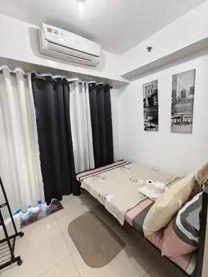a room with a bed and a air conditioner at Sea Residence MOA - JULIZA STAYCATION in Manila
