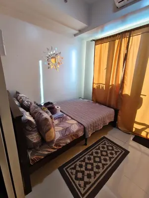 a small room with a bed and a window at Sea Residence MOA - JULIZA STAYCATION in Manila