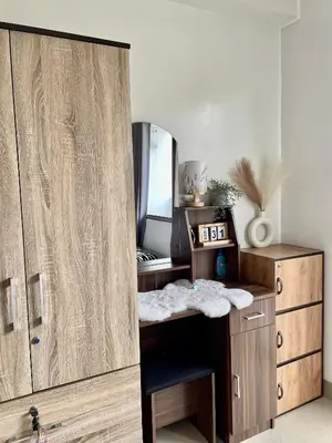 a room with a wooden desk with a mirror at 12 Minutes from Mall of Asia - Spacious Condo with Balcony & Hot Shower in Manila