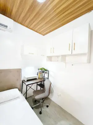 a bedroom with a bed and a desk and a chair at Eco's Place GenTri - Family Bungalow in General Trias