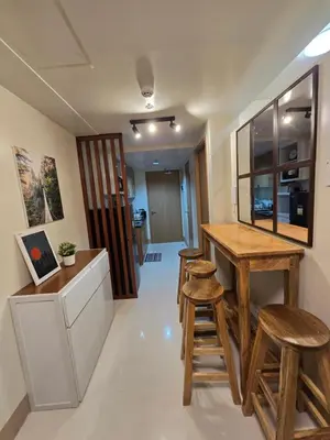 a kitchen with a wooden table and stools at Shore 3 Residences tower 3 in Manila