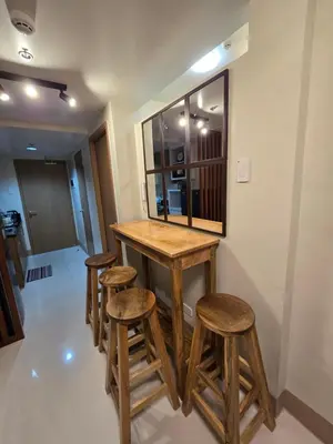 a bathroom with a wooden bar with four stools at Shore 3 Residences tower 3 in Manila