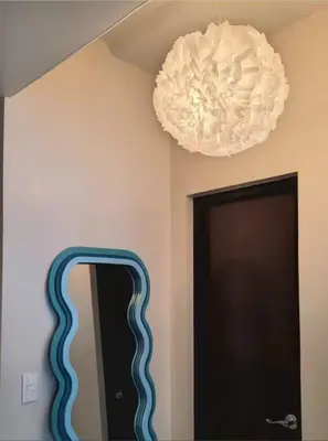 a light hanging from a ceiling next to a mirror at Funky HQ - 1BR Eastwood Global Plaza in Manila