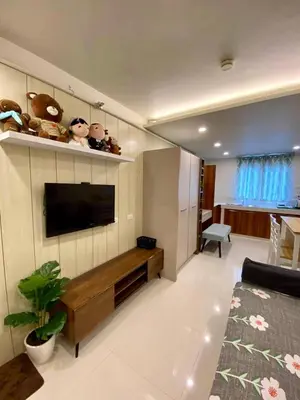 a living room with a flat screen tv on the wall at Cozy Studio Sorrento Oasis Rosario Pasig in Manila