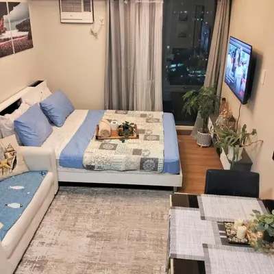 a living room with two beds and a tv at Flair Towers Urban Resort Staycations in Manila