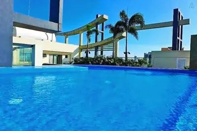 a large blue swimming pool in front of a building at Flair Towers Urban Resort Staycations in Manila