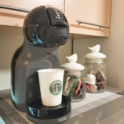a coffee maker sitting on a counter with a cup at Flair Towers Urban Resort Staycations in Manila