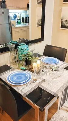 a table with plates and glasses on it in a kitchen at Flair Towers Urban Resort Staycations in Manila