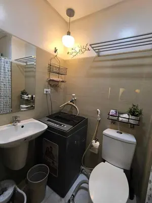 a bathroom with a white toilet and a sink at EmFress Suites in Manila