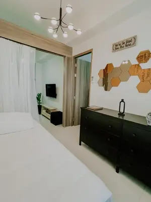 a bedroom with a large bed and a mirror at 2Br Cozy Unit near Manila International Airport in Manila