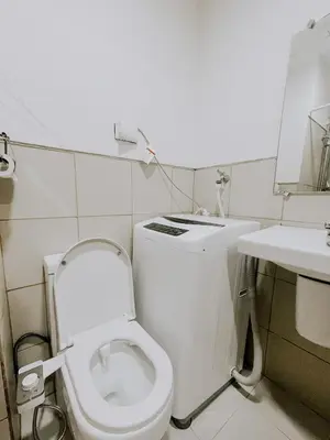 a white bathroom with a toilet and a sink at 2Br Cozy Unit near Manila International Airport in Manila
