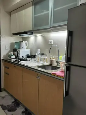 a kitchen with a sink and a refrigerator at SerenityPads in Manila
