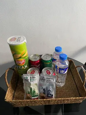 a basket filled with drinks and water on a table at Ohana buenbyahe affordable staycation at F RESIDENCEs near at mrt shaw megamall and starmall in Manila