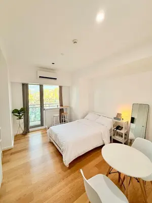 a white bedroom with a bed and a table and chairs at Studio Unit Staycation near Rockwell Mandaluyong FREE Pool Access in Manila