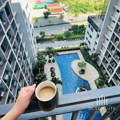 a person holding a cup of coffee on a balcony at Cozy Vibes near Moa & Naia Airport Wifi Netflix-Duxe8 in Manila