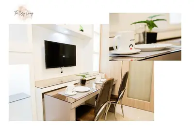a room with a table with chairs and a tv at Staycation near Moa new room in Manila