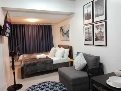 a living room with a bed and a couch at Downtown Makati Malls and Bars at your doorsteps in Manila
