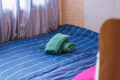 a bed with a green pillow on top of it at Eccentric Escape Stylish Makati Urban Swim Gym 4034 in Manila