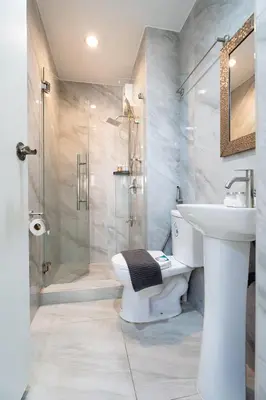 a bathroom with a toilet and a sink and a shower at Greenbelt Makati Condo with Balcony & Park Views in Manila