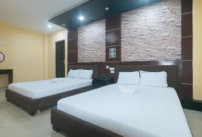 a bedroom with two beds and a brick wall at Ranchotel General Trias Cavite by RedDoorz in Uldugan