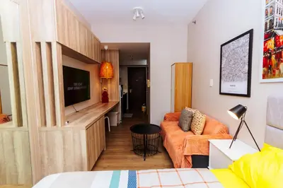 a living room with a couch and a television at The Laughing Loft Cosmopolitan Comfort Gym Swim Park 2428 in Manila