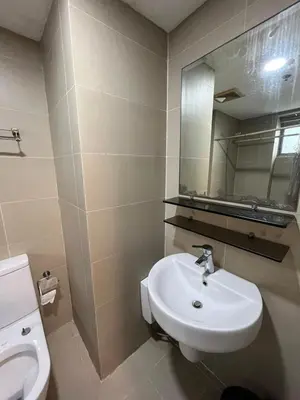 a bathroom with a sink and a toilet and a mirror at The Serenity Tower 2706 in Manila