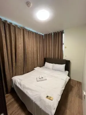 a bedroom with a bed with white sheets and a tray on it at The Serenity Tower 2706 in Manila