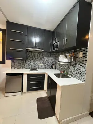 a kitchen with black cabinets and a sink at Kiean Leases in Manila