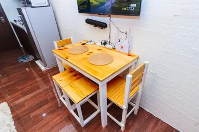 a table with two chairs and a television on a wall at Serene City Stay Trendy Cozy Makati Condo Fun Swim Gym Netflix 4047 in Manila