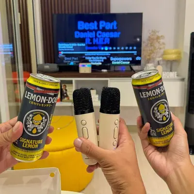 two people holding up two bottles of kennforth dj and a microphone at Serene Cove Azure in Manila
