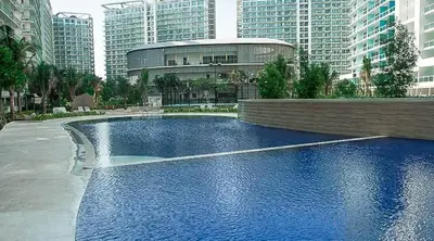 a swimming pool with a fountain in a city at Serene Cove Azure in Manila