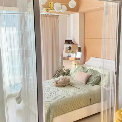 a small bedroom with a bed with a glass wall at Serene Cove Azure in Manila