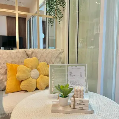 a table with a flower on top of a couch at Serene Cove Azure in Manila