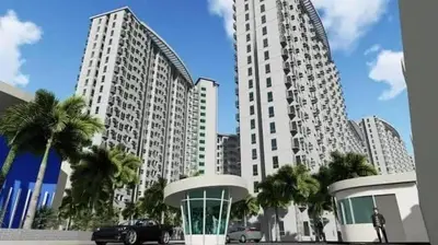a large white building with palm trees in front of it at Kaireese Properties in Manila