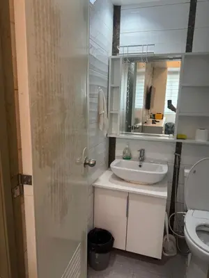 a bathroom with a sink and a toilet and a mirror at Greenhills shopping center 2BR condominium in Manila