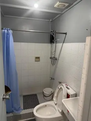 a small bathroom with a toilet and a sink at Greenhills shopping center studio condominium in Manila