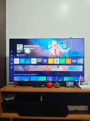 a flat screen tv sitting on top of a table at Cozy & Stylish Staycation and Netflix - WiFi and Pool in Manila