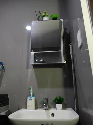 a small bathroom with a sink and a mirror at Cozy & Stylish Staycation and Netflix - WiFi and Pool in Manila