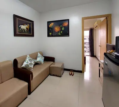 a living room with a couch and a tv at Solemare Parksuites in Manila