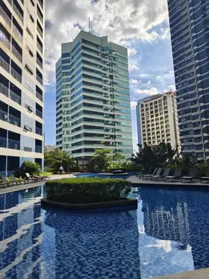 a pool in the middle of two tall buildings at Air Residences by Christine Suites PH Makati City in Manila