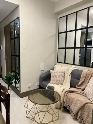 a living room with a couch and a glass table at 5-Star Feel and Step in Luxury at Fame Residences in Manila