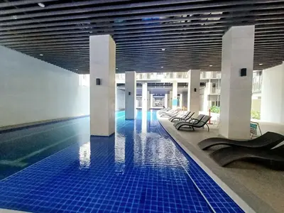 a pool in a building with a blue tile floor at My Staycation moa area S Residences tower1 in Manila