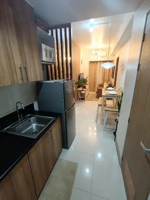 a kitchen with a sink and a refrigerator at CLMN Staycation Metro Manila in Manila