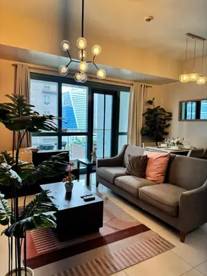 a living room with a couch and a table at BGC One Uptown 2bedroom with balcony and 1 free parking in Manila