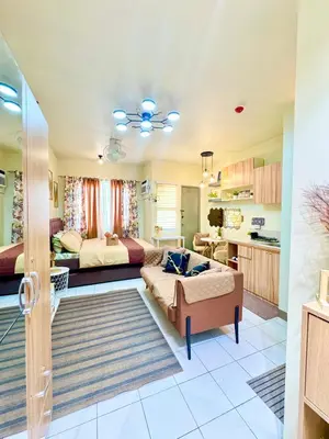 a living room with two beds and a kitchen at D88Staycations 105- Condo Staycation beside Enchanted Kingdom in Santa Rosa