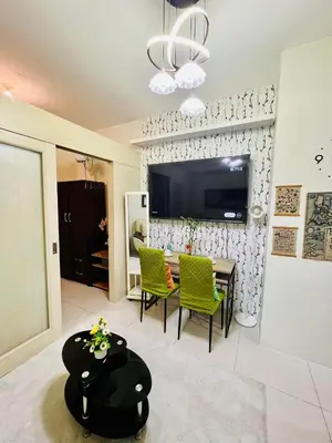 a living room with a table and chairs and a tv at amaya in Manila