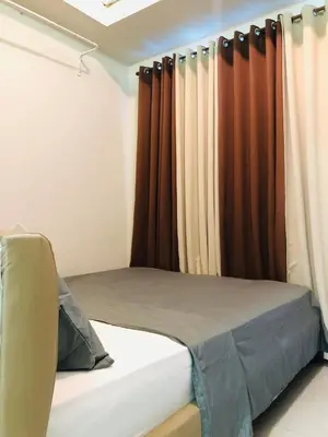 a bed in a room with curtains in a room at amaya in Manila