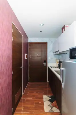 a kitchen with a wooden door and a refrigerator at Urban Hideaway Cozy Makati Giggles Swim Gym Park Laugh Eat 3352 in Manila